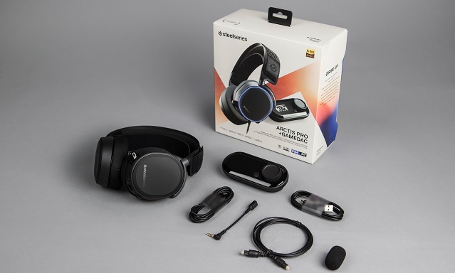 The Arctis Pro + (Plus) with box, game DAC, and wires on a grey background. 